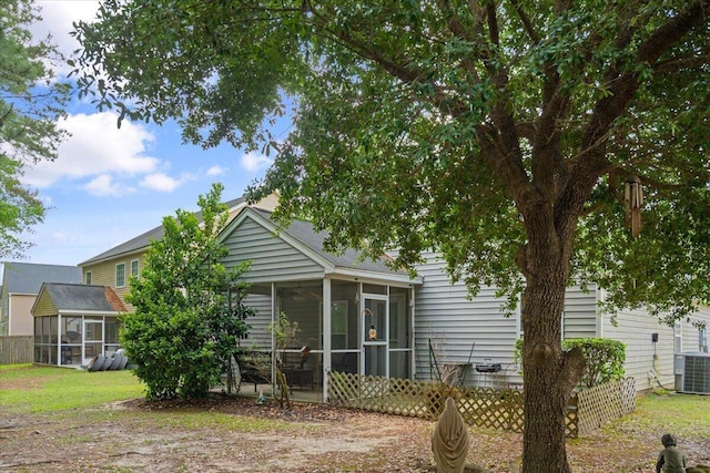 back of property featuring a sunroom, central AC unit, and fence