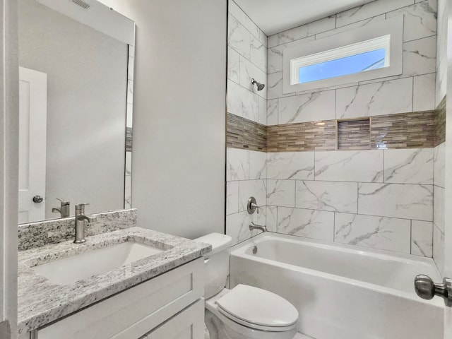 full bathroom featuring toilet, vanity, and tiled shower / bath