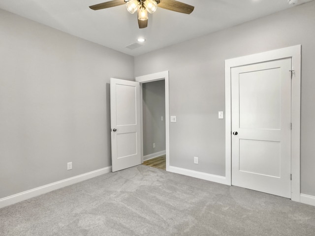 unfurnished bedroom featuring light colored carpet and ceiling fan