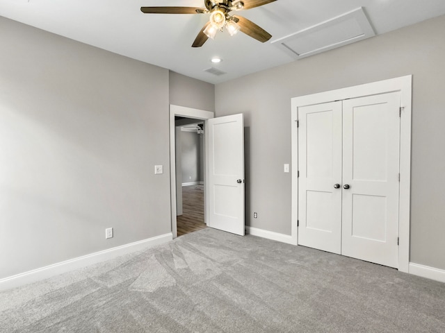 unfurnished bedroom with a closet, light colored carpet, and ceiling fan