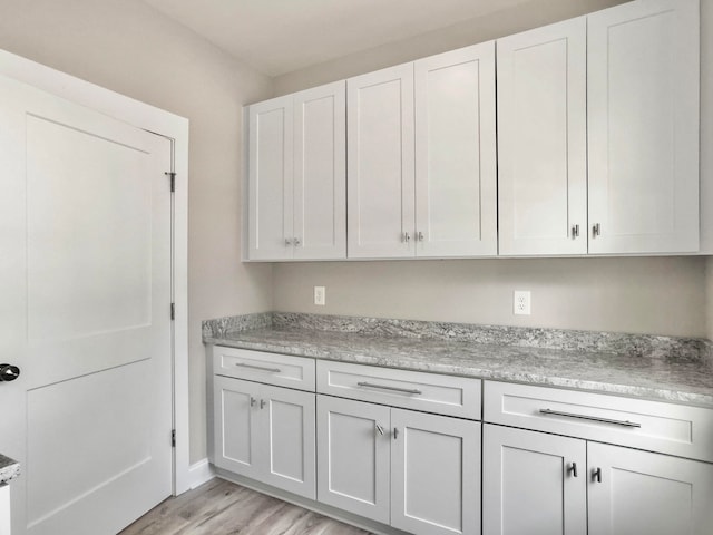 clothes washing area with light wood-type flooring