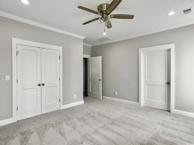 unfurnished bedroom with ornamental molding, a closet, light colored carpet, and ceiling fan