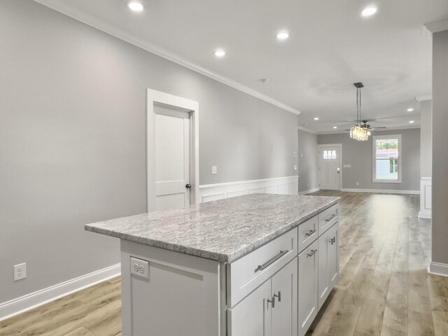 4566 Durant Ave, North Charleston, SC 29405 - kitchen with ornamental molding, ceiling fan, a center island, light wood-style flooring, and white cabinets