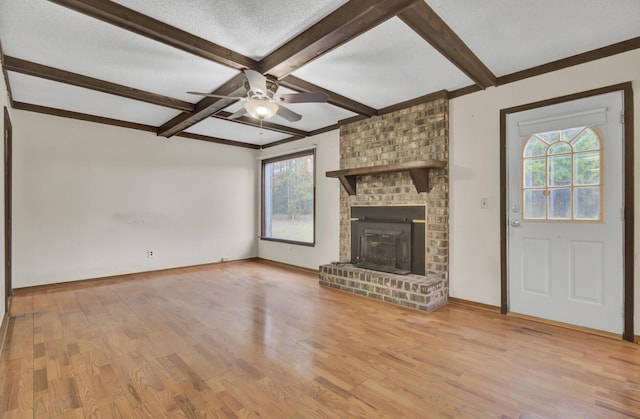 unfurnished living room with beamed ceiling, ceiling fan, a wealth of natural light, and light hardwood / wood-style flooring