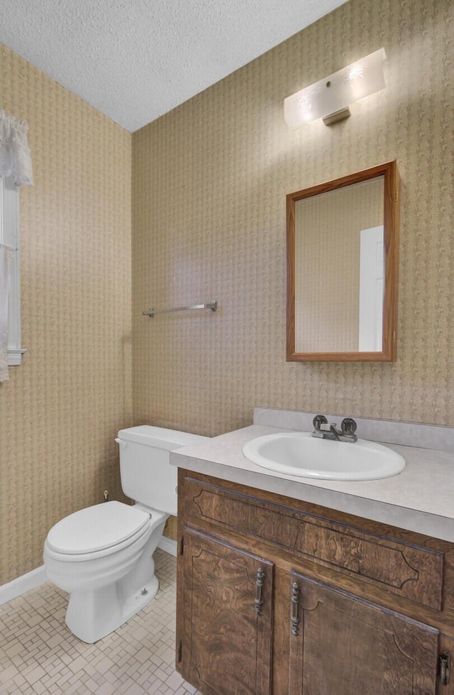 bathroom featuring tile patterned floors, vanity, a textured ceiling, and toilet