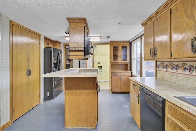 kitchen with a textured ceiling, a center island, and black appliances