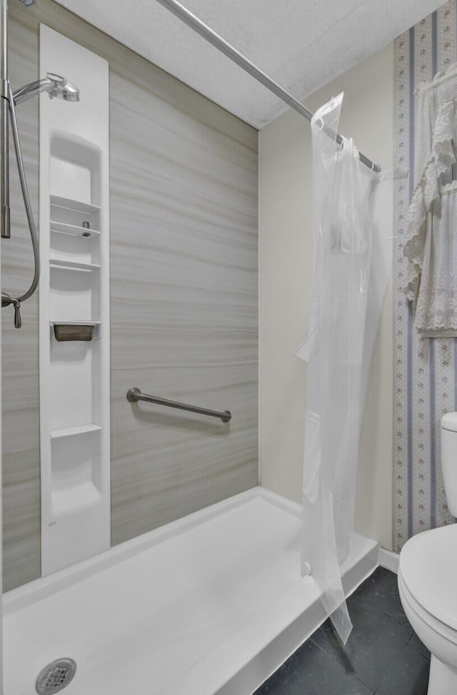 bathroom featuring tile patterned flooring, a shower with curtain, and toilet