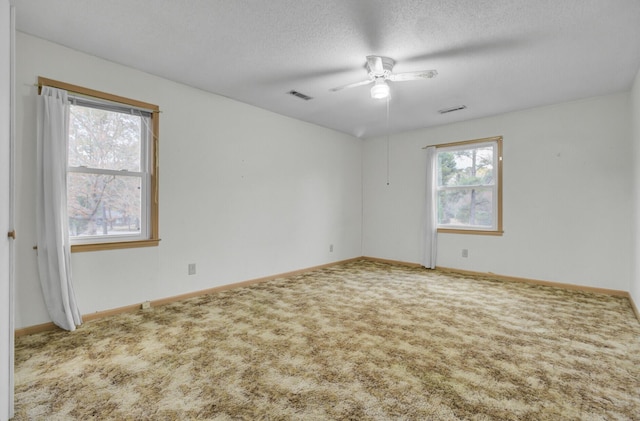 unfurnished room featuring ceiling fan, carpet floors, and a textured ceiling