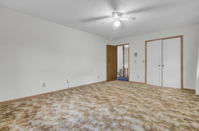 unfurnished bedroom featuring carpet, a textured ceiling, and ceiling fan