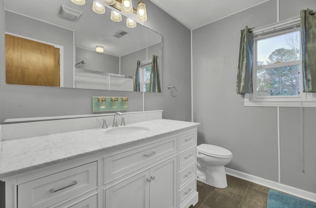 bathroom featuring an enclosed shower, vanity, and toilet