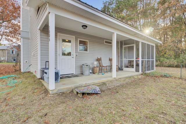 back of property featuring a yard, a patio, and a sunroom