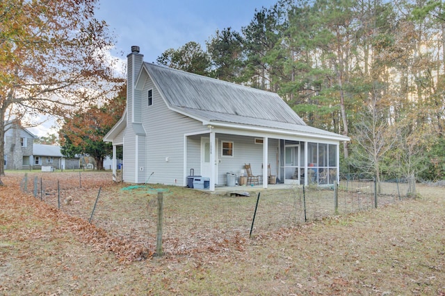 view of front of house with a sunroom and a front lawn