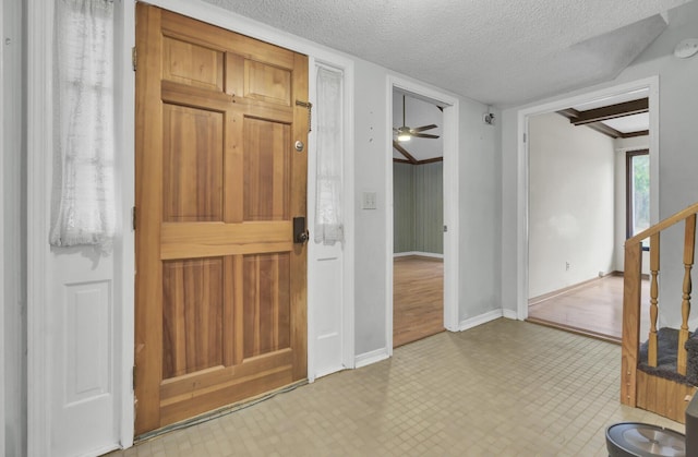 entrance foyer featuring ceiling fan and a textured ceiling