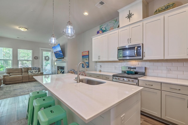 129 Howard Mary Dr Unit A, Charleston, SC 29412 - kitchen featuring stainless steel appliances, open floor plan, light wood-style flooring, light countertops, and backsplash