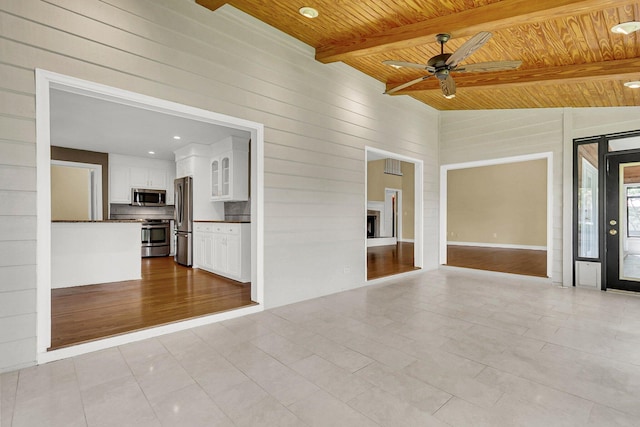 empty room with wood ceiling, ceiling fan, lofted ceiling with beams, and light wood-type flooring