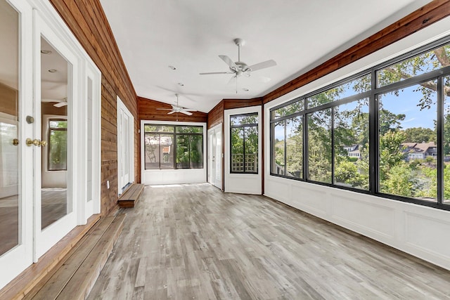 unfurnished sunroom with ceiling fan and a wealth of natural light