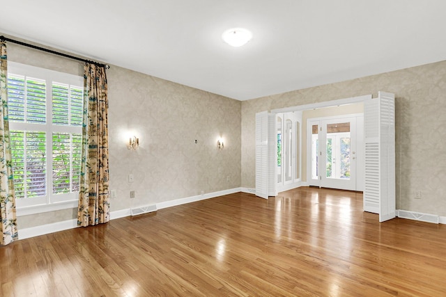 empty room with a healthy amount of sunlight and wood-type flooring