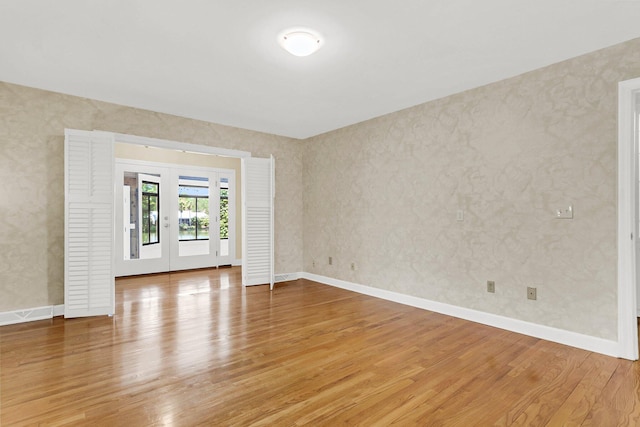 spare room featuring french doors and wood-type flooring