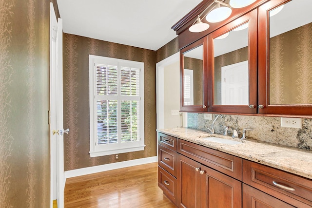 bathroom featuring backsplash, hardwood / wood-style flooring, and vanity