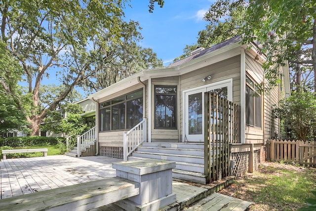 view of front of property featuring a sunroom and a wooden deck