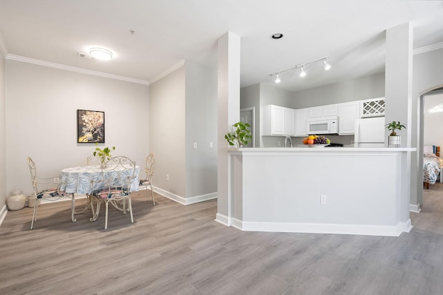 kitchen featuring light wood finished floors, white cabinets, white appliances, and crown molding