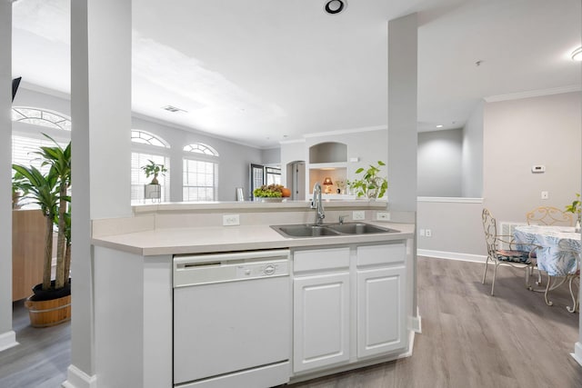 kitchen with light countertops, ornamental molding, white dishwasher, and a sink