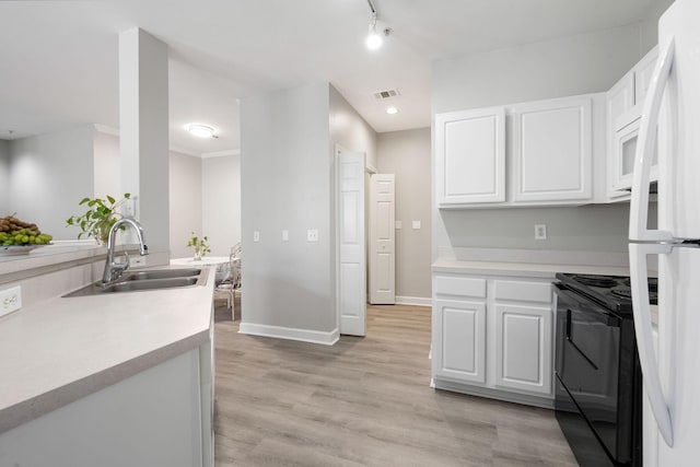 kitchen featuring a sink, light wood-type flooring, black electric range oven, and white cabinetry