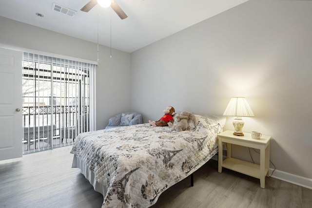 bedroom with ceiling fan, wood finished floors, visible vents, and baseboards