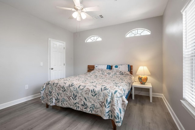 bedroom with visible vents, baseboards, and wood finished floors