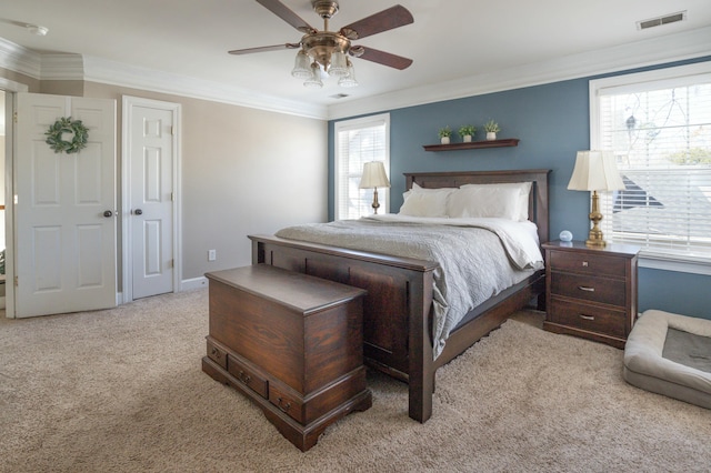 carpeted bedroom with ceiling fan and ornamental molding