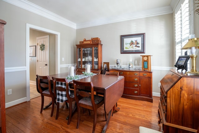 dining room featuring ornamental molding and light wood-type flooring