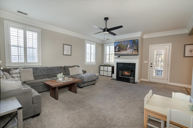 carpeted living room featuring ornamental molding and ceiling fan