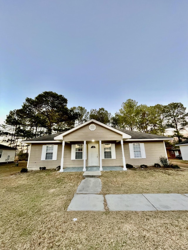 ranch-style home featuring a front lawn and a porch