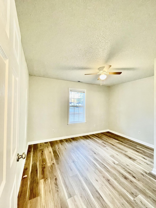 unfurnished room with ceiling fan, hardwood / wood-style floors, and a textured ceiling