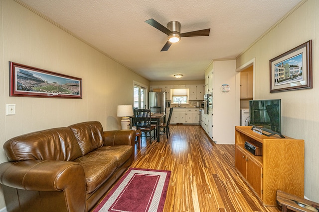 living room with sink, a textured ceiling, wood-type flooring, and ceiling fan