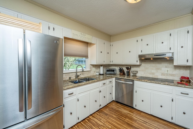 kitchen featuring appliances with stainless steel finishes, sink, dark hardwood / wood-style flooring, white cabinetry, and dark stone counters