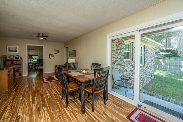 dining space with hardwood / wood-style floors, a textured ceiling, and ceiling fan