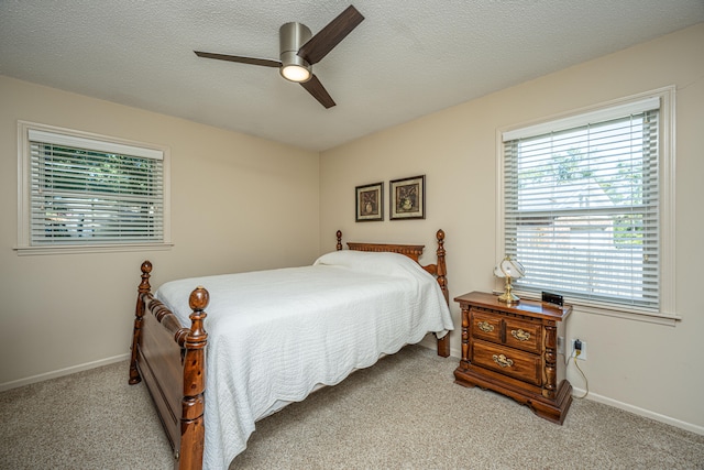 bedroom featuring light carpet, a textured ceiling, and ceiling fan