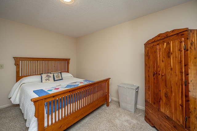 bedroom with a textured ceiling and light colored carpet