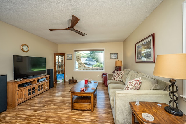 living room featuring a textured ceiling, hardwood / wood-style flooring, and ceiling fan