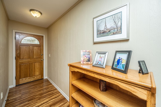 entryway featuring ornamental molding and dark hardwood / wood-style flooring