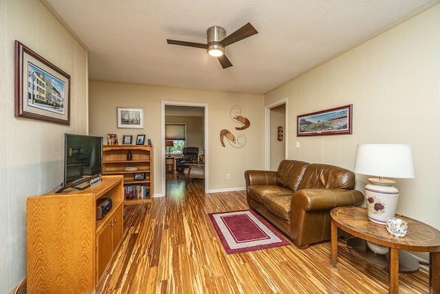 living room with ceiling fan, wood-type flooring, and a textured ceiling