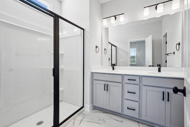 full bath with double vanity, marble finish floor, a shower stall, and a sink