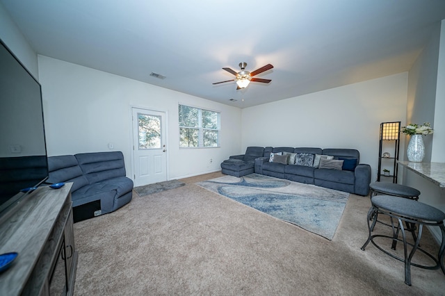 carpeted living room with ceiling fan