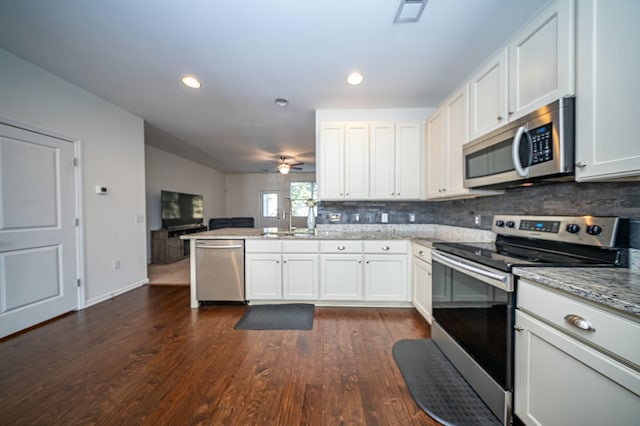 kitchen featuring sink, backsplash, stainless steel appliances, light stone countertops, and white cabinets