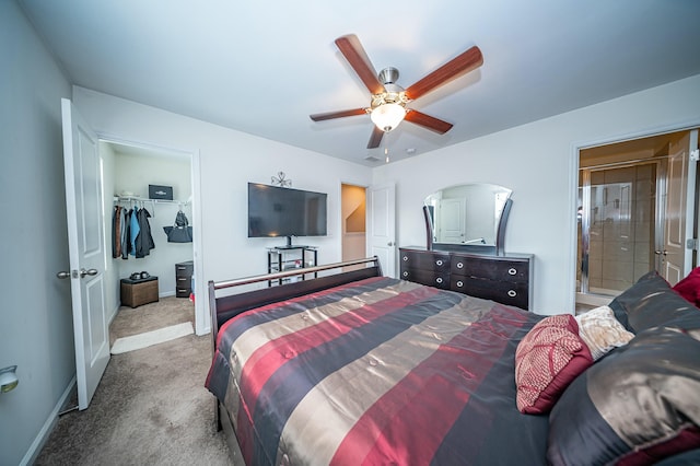 bedroom with ceiling fan, ensuite bathroom, carpet flooring, a walk in closet, and a closet