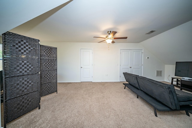 interior space with ceiling fan, light colored carpet, and vaulted ceiling