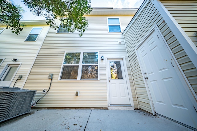 back of property with central AC unit and a patio area