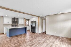 119 Silver King Ave, Cross, SC 29436 - kitchen with black refrigerator with ice dispenser, wall chimney range hood, light wood-type flooring, light countertops, and white cabinets