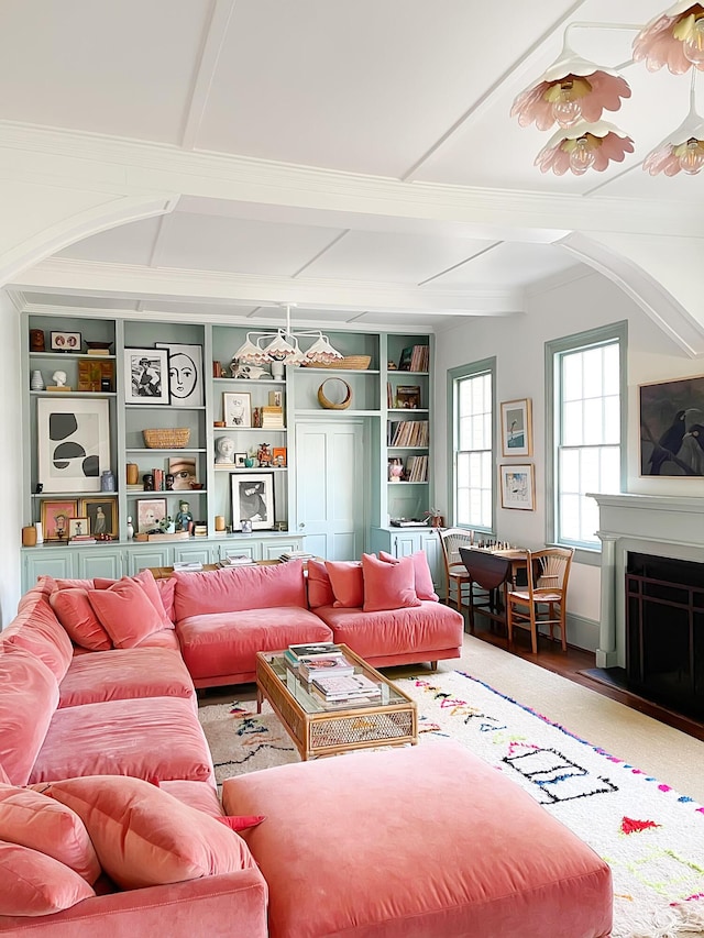 living room with beamed ceiling and built in features